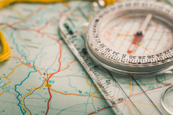 A map with a compass and ruler on top, used for navigation and orientation.